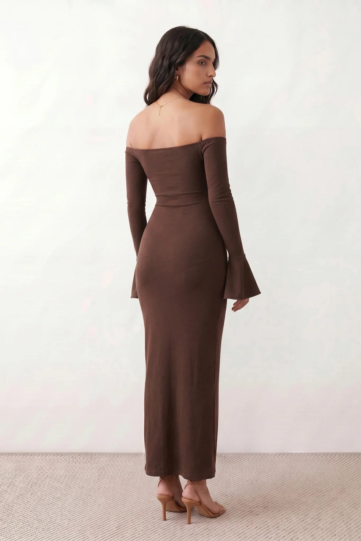 Woman wearing the strapless mermaid maxi dress with a sweetheart neckline, statement shoulder bow, matching long bell-cuff gloves, fitted silhouette and floor-length hem, ideal for weddings, black-tie events and formal occasions.