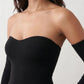 Woman wearing the strapless mermaid maxi dress with a sweetheart neckline, statement shoulder bow, matching long bell-cuff gloves, fitted silhouette and floor-length hem, ideal for weddings, black-tie events and formal occasions.