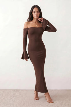Woman wearing the strapless mermaid maxi dress with a sweetheart neckline, statement shoulder bow, matching long bell-cuff gloves, fitted silhouette and floor-length hem, ideal for weddings, black-tie events and formal occasions.
