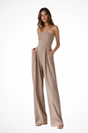 Woman wearing a beige strapless jumpsuit on a white background