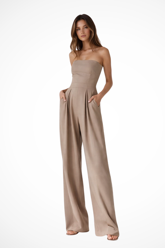 Woman wearing a beige strapless jumpsuit on a white background