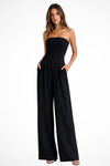 Woman wearing a black strapless jumpsuit on a white background