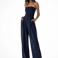 Woman wearing a strapless navy jumpsuit on a white background