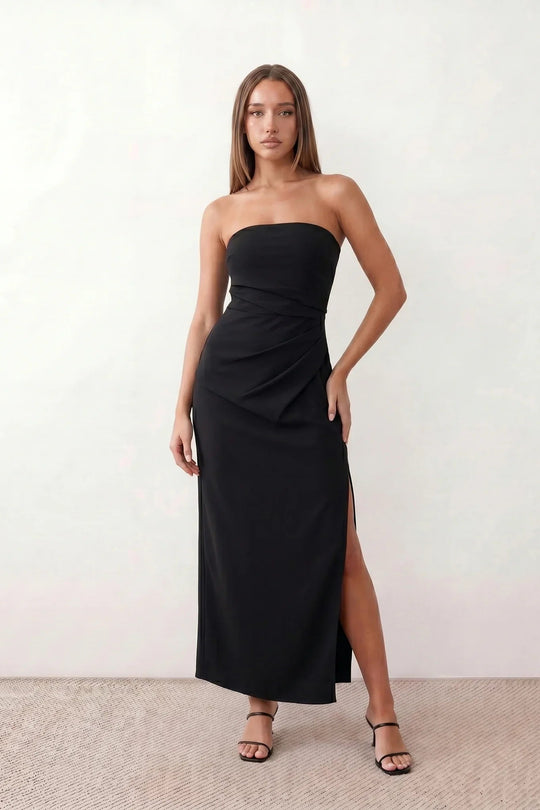 Woman wearing the strapless square neck fitted maxi dress with a structured fold-over bodice, ruched waist, low back and side slit, elegant full-length evening gown for weddings, black-tie events and formal occasions.