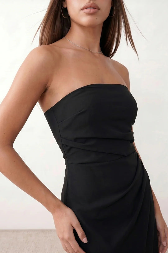 Woman wearing the strapless square neck fitted maxi dress with a structured fold-over bodice, ruched waist, low back and side slit, elegant full-length evening gown for weddings, black-tie events and formal occasions.