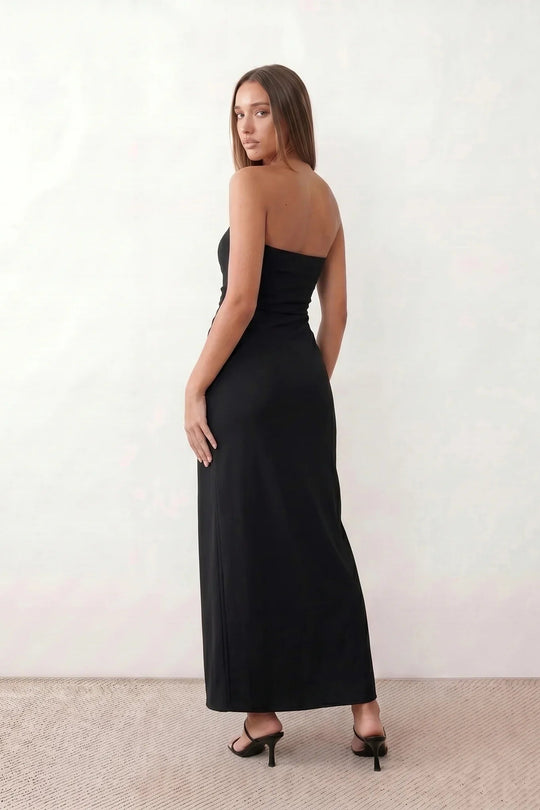 Woman wearing the strapless square neck fitted maxi dress with a structured fold-over bodice, ruched waist, low back and side slit, elegant full-length evening gown for weddings, black-tie events and formal occasions.