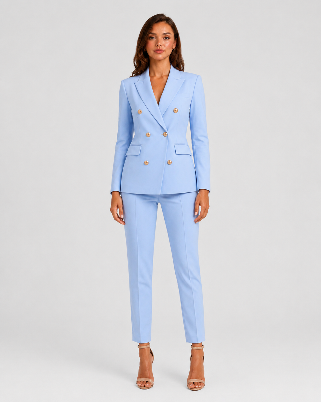 Woman wearing a tailored double-breasted blazer and matching trousers set with a structured silhouette and polished modern tailoring.