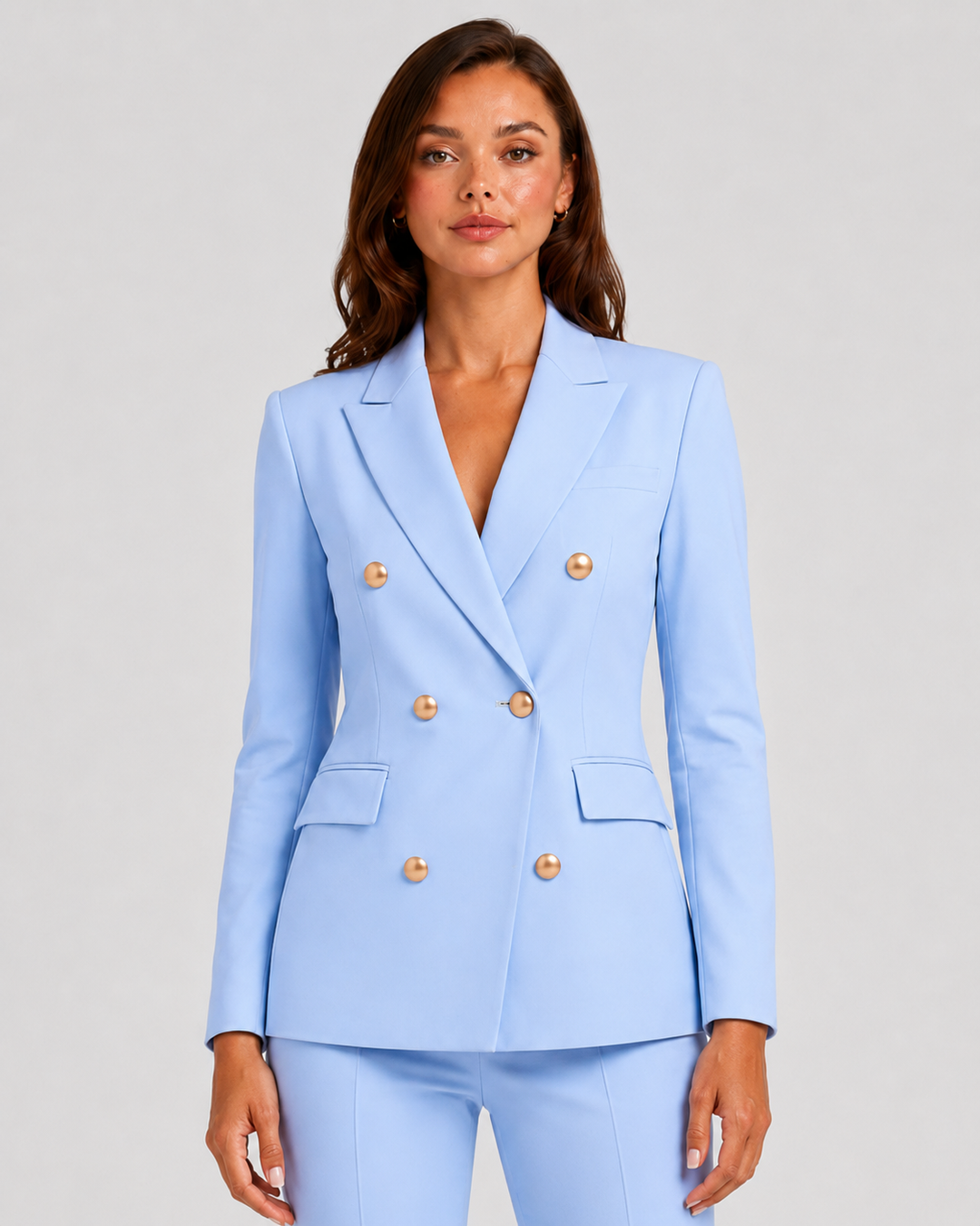 Woman wearing a tailored double-breasted blazer and matching trousers set with a structured silhouette and polished modern tailoring.