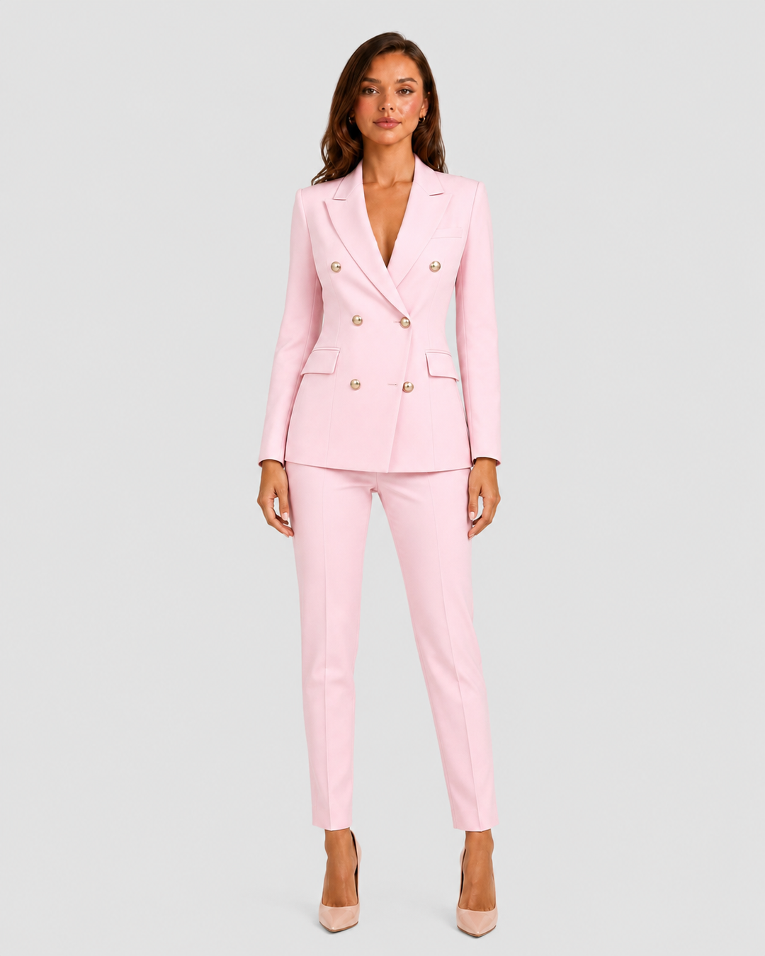 Woman wearing a tailored double-breasted blazer and matching trousers set with a structured silhouette and polished modern tailoring.