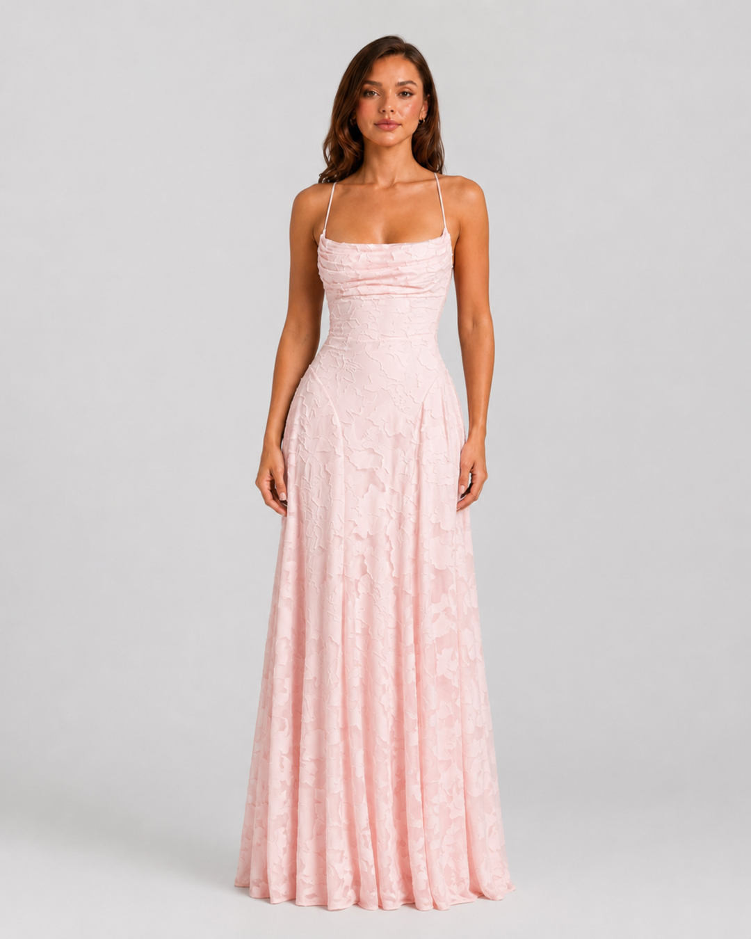 Woman wearing a textured floral maxi dress with a fitted bodice, delicate straps, elegant neckline, and flowing skirt for wedding guest and occasion wear.