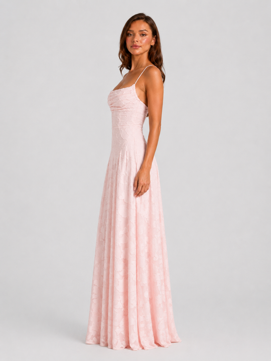 Woman wearing a textured floral maxi dress with a fitted bodice, delicate straps, elegant neckline, and flowing skirt for wedding guest and occasion wear.