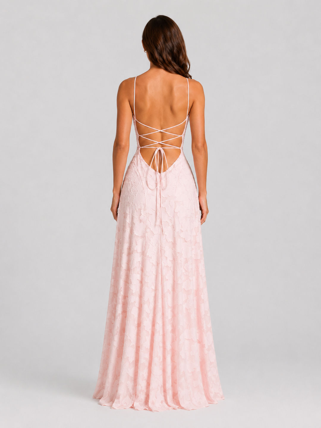 Woman wearing a textured floral maxi dress with a fitted bodice, delicate straps, elegant neckline, and flowing skirt for wedding guest and occasion wear.