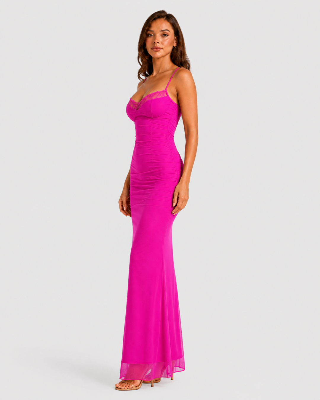 Woman wearing a fitted lace mesh corset dress with underwired cups, delicate lace trim, and a body-contouring silhouette designed for elegant evening occasions.