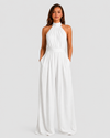 Woman wearing a halter neck wide leg jumpsuit with a defined waistband, flowing silhouette, sleeveless design, and elegant draped fabric for formal occasions.