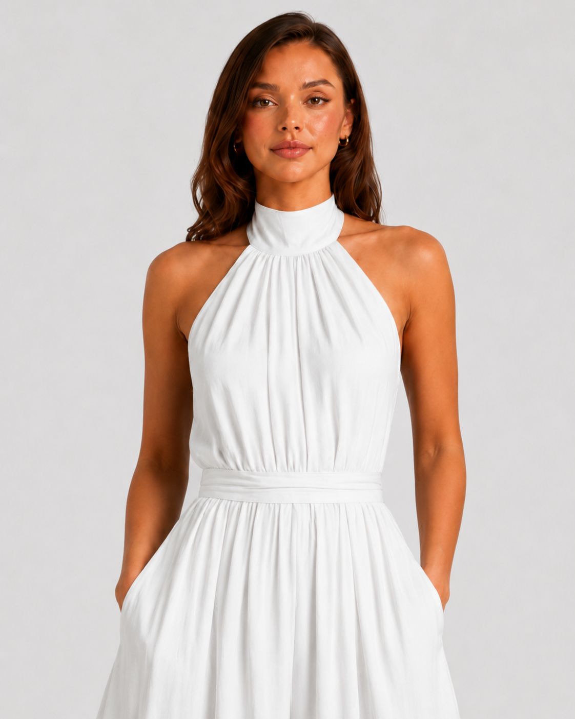 Woman wearing a halter neck wide leg jumpsuit with a defined waistband, flowing silhouette, sleeveless design, and elegant draped fabric for formal occasions.