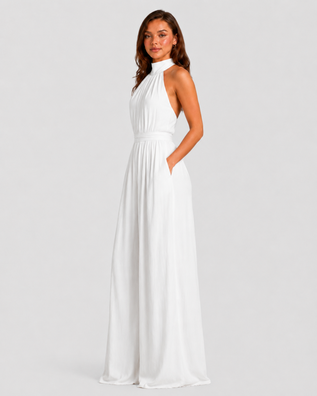 Woman wearing a halter neck wide leg jumpsuit with a defined waistband, flowing silhouette, sleeveless design, and elegant draped fabric for formal occasions.