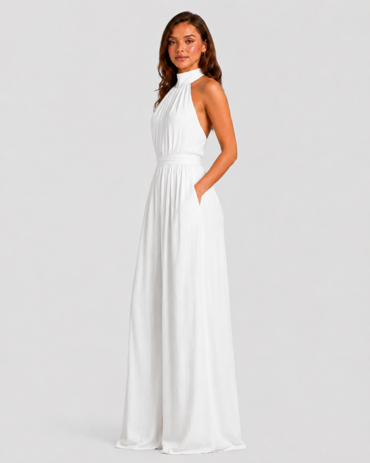 Woman wearing a halter neck wide leg jumpsuit with a defined waistband, flowing silhouette, sleeveless design, and elegant draped fabric for formal occasions.