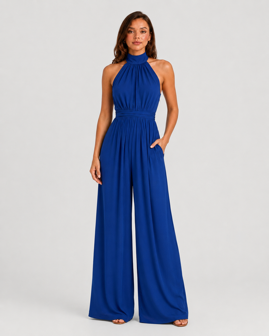 Woman wearing a halter neck wide leg jumpsuit with a defined waistband, flowing silhouette, sleeveless design, and elegant draped fabric for formal occasions.