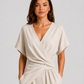 Woman wearing a lightweight wrap front co-ord set with relaxed cropped wide-leg trousers, styled for elegant summer occasions and holiday wear.