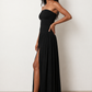 Woman wearing the Zofia strapless A-line maxi dress featuring a smocked square-neck bodice, shirred waist, flowing A-line skirt with a side slit, and a backless design.