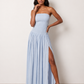 Woman wearing the Zofia strapless A-line maxi dress featuring a smocked square-neck bodice, shirred waist, flowing A-line skirt with a side slit, and a backless design.
