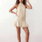Bella Glossy Halter Mini Dress with a halter mock neckline, tie-back closure, smocked waist, open back, and tiered ruffle mini skirt in a glossy finish, available in Beige, Red, Purple, Yellow, Pink, and Light Blue.