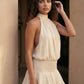 Bella Glossy Halter Mini Dress with a halter mock neckline, tie-back closure, smocked waist, open back, and tiered ruffle mini skirt in a glossy finish, available in Beige, Red, Purple, Yellow, Pink, and Light Blue.