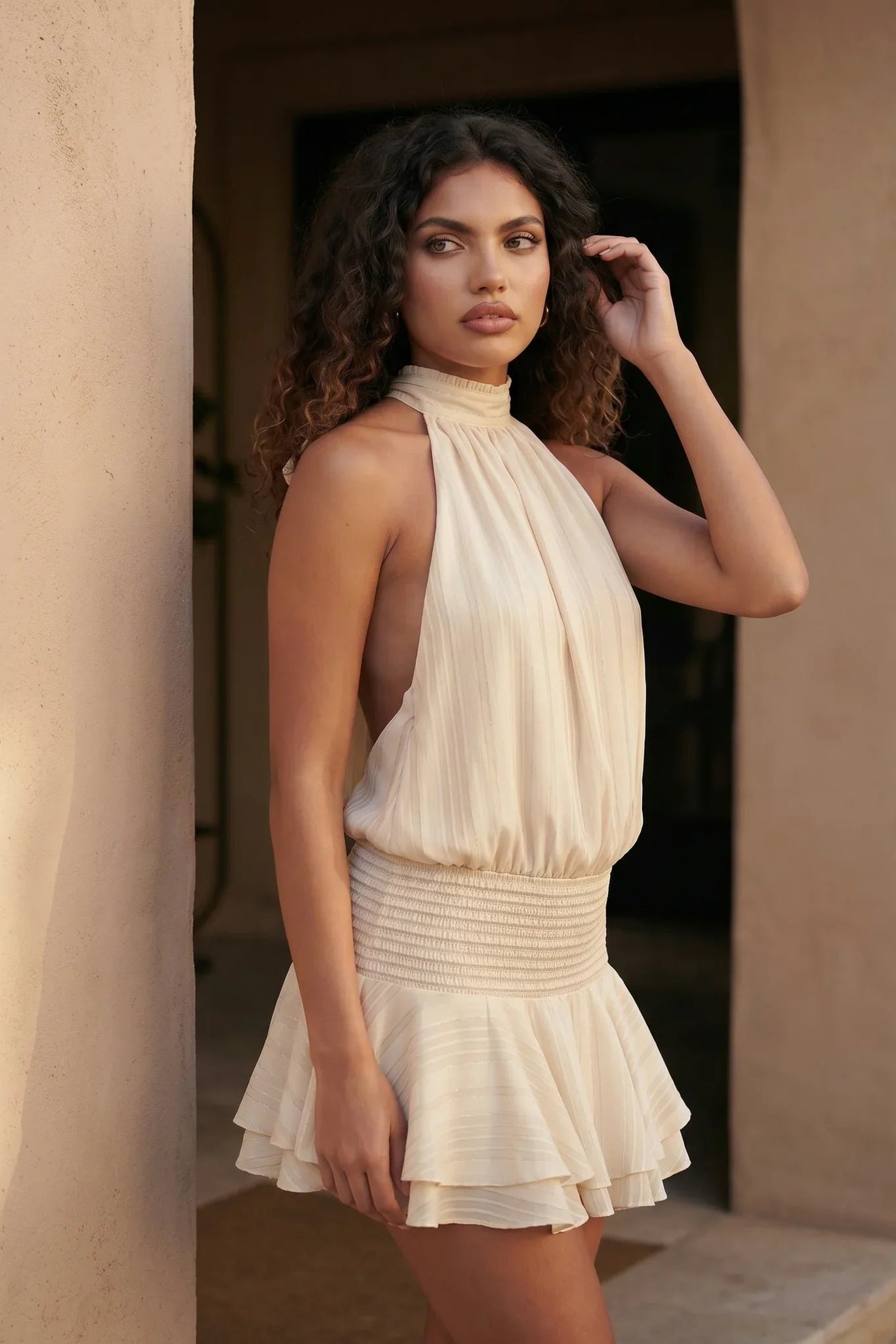 Bella Glossy Halter Mini Dress with a halter mock neckline, tie-back closure, smocked waist, open back, and tiered ruffle mini skirt in a glossy finish, available in Beige, Red, Purple, Yellow, Pink, and Light Blue.