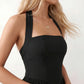 Maren halter backless mini dress with a square halter neckline, corset-seamed bodice, fully open back with tie-neck closure, and a flared A-line mini skirt. Available in black and white.