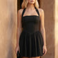 Maren halter backless mini dress with a square halter neckline, corset-seamed bodice, fully open back with tie-neck closure, and a flared A-line mini skirt. Available in black and white.