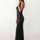 Woman wearing the Mihaela sequined low back maxi dress featuring allover sequin mesh, a square neckline, wide shoulder straps, a low open back, and a fitted floor-length sheath silhouette.