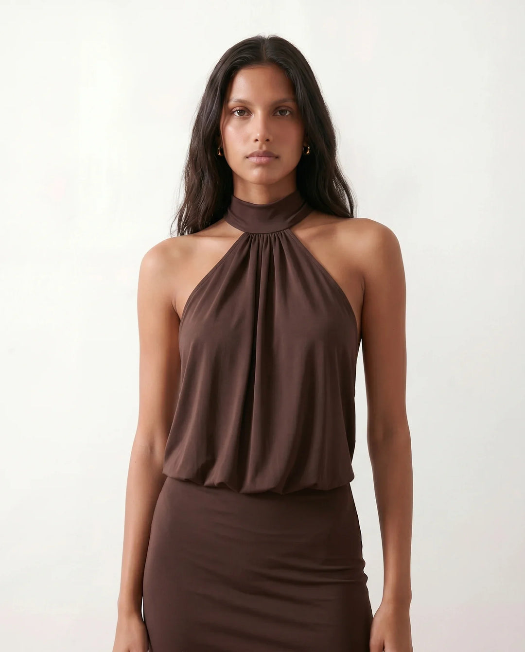 Woman wearing the Mae silk halter mini dress featuring a draped halter neckline, open back with adjustable tie-neck fastening, fitted bodycon mini silhouette, and smooth silk-look fabric, ideal for weddings, cocktail parties, and evening occasions.