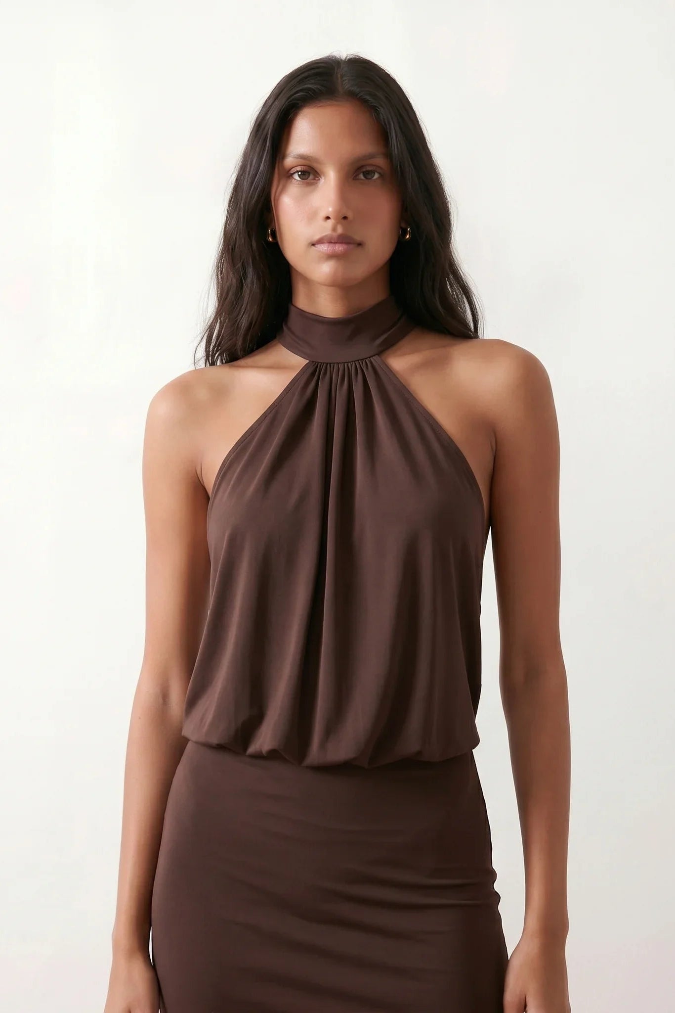 Woman wearing the Mae silk halter mini dress featuring a draped halter neckline, open back with adjustable tie-neck fastening, fitted bodycon mini silhouette, and smooth silk-look fabric, ideal for weddings, cocktail parties, and evening occasions.