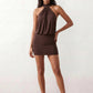 Woman wearing the Mae silk halter mini dress featuring a draped halter neckline, open back with adjustable tie-neck fastening, fitted bodycon mini silhouette, and smooth silk-look fabric, ideal for weddings, cocktail parties, and evening occasions.