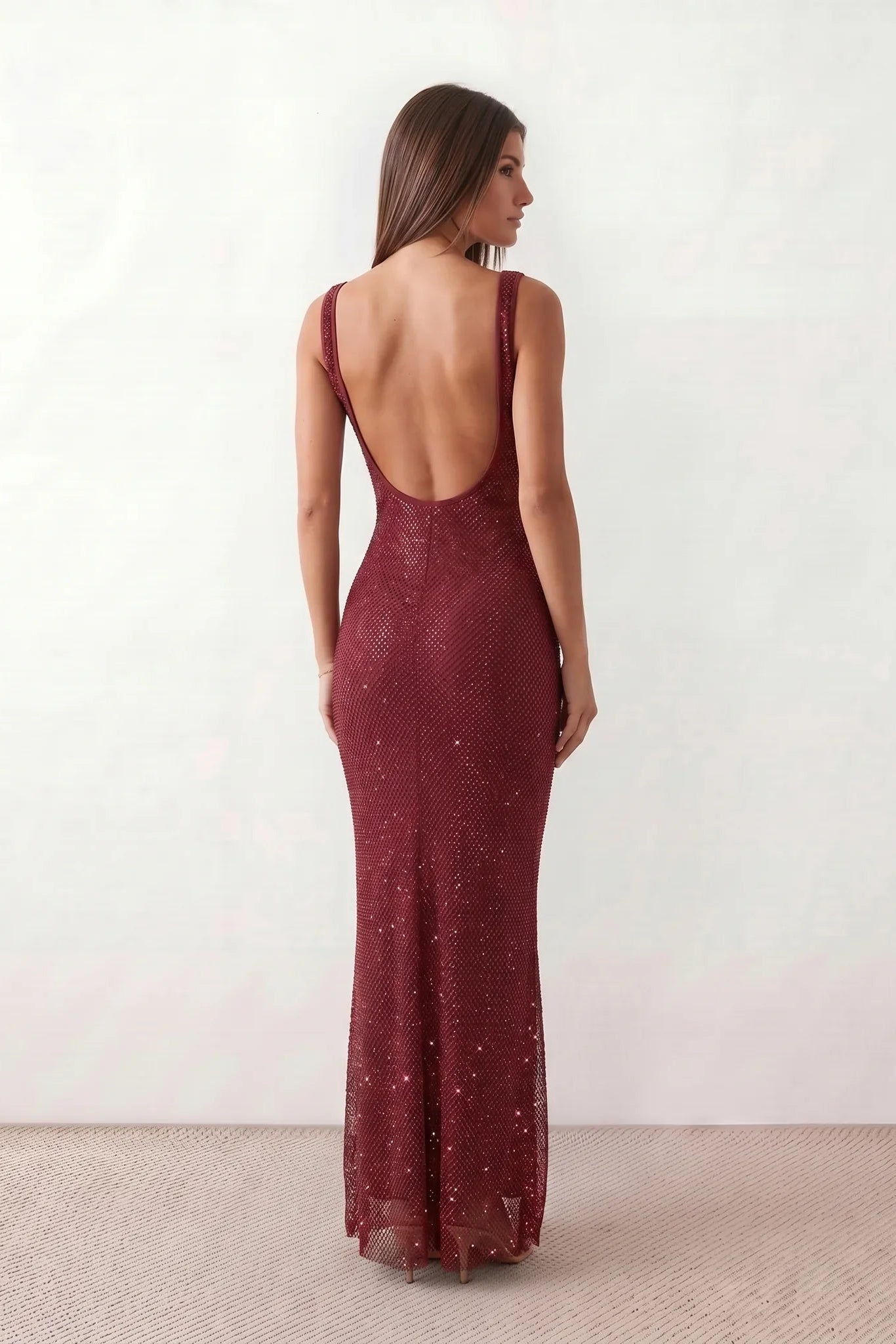 Woman wearing the Mihaela sequined low back maxi dress featuring allover sequin mesh, a square neckline, wide shoulder straps, a low open back, and a fitted floor-length sheath silhouette.