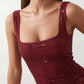 Woman wearing the Mihaela sequined low back maxi dress featuring allover sequin mesh, a square neckline, wide shoulder straps, a low open back, and a fitted floor-length sheath silhouette.