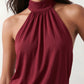 Woman wearing the Mae silk halter mini dress featuring a draped halter neckline, open back with adjustable tie-neck fastening, fitted bodycon mini silhouette, and smooth silk-look fabric, ideal for weddings, cocktail parties, and evening occasions.