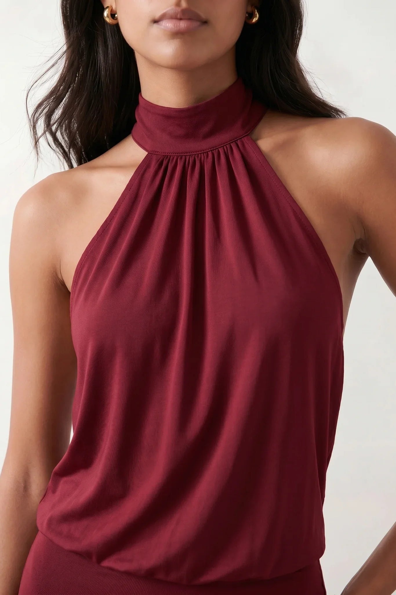 Woman wearing the Mae silk halter mini dress featuring a draped halter neckline, open back with adjustable tie-neck fastening, fitted bodycon mini silhouette, and smooth silk-look fabric, ideal for weddings, cocktail parties, and evening occasions.
