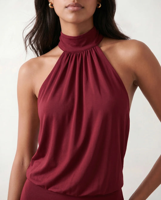 Woman wearing the Mae silk halter mini dress featuring a draped halter neckline, open back with adjustable tie-neck fastening, fitted bodycon mini silhouette, and smooth silk-look fabric, ideal for weddings, cocktail parties, and evening occasions.