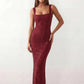 Woman wearing the Mihaela sequined low back maxi dress featuring allover sequin mesh, a square neckline, wide shoulder straps, a low open back, and a fitted floor-length sheath silhouette.