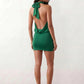 Woman wearing the Mae silk halter mini dress featuring a draped halter neckline, open back with adjustable tie-neck fastening, fitted bodycon mini silhouette, and smooth silk-look fabric, ideal for weddings, cocktail parties, and evening occasions.
