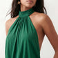 Woman wearing the Mae silk halter mini dress featuring a draped halter neckline, open back with adjustable tie-neck fastening, fitted bodycon mini silhouette, and smooth silk-look fabric, ideal for weddings, cocktail parties, and evening occasions.