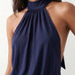 Woman wearing the Mae silk halter mini dress featuring a draped halter neckline, open back with adjustable tie-neck fastening, fitted bodycon mini silhouette, and smooth silk-look fabric, ideal for weddings, cocktail parties, and evening occasions.