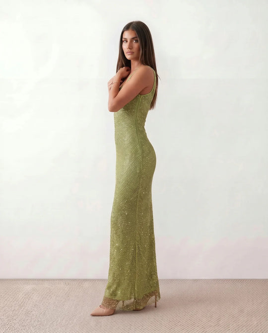 Woman wearing the Mihaela sequined low back maxi dress featuring allover sequin mesh, a square neckline, wide shoulder straps, a low open back, and a fitted floor-length sheath silhouette.