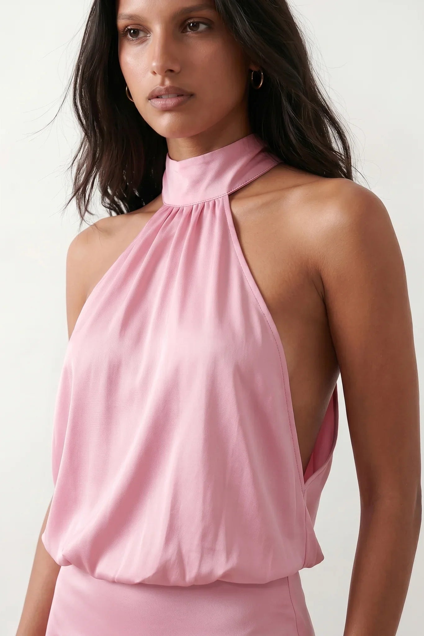 Woman wearing the Mae silk halter mini dress featuring a draped halter neckline, open back with adjustable tie-neck fastening, fitted bodycon mini silhouette, and smooth silk-look fabric, ideal for weddings, cocktail parties, and evening occasions.