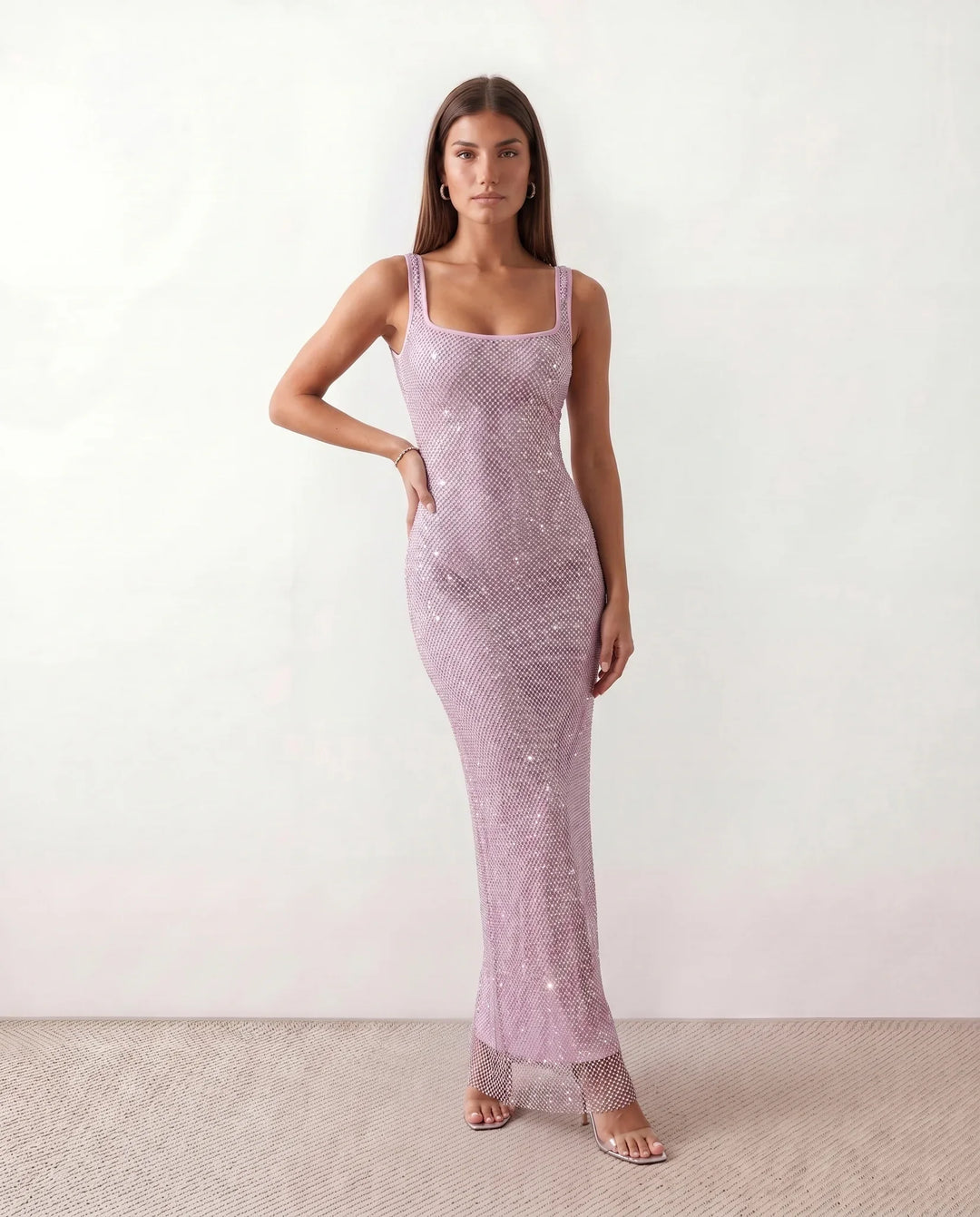 Woman wearing the Mihaela sequined low back maxi dress featuring allover sequin mesh, a square neckline, wide shoulder straps, a low open back, and a fitted floor-length sheath silhouette.