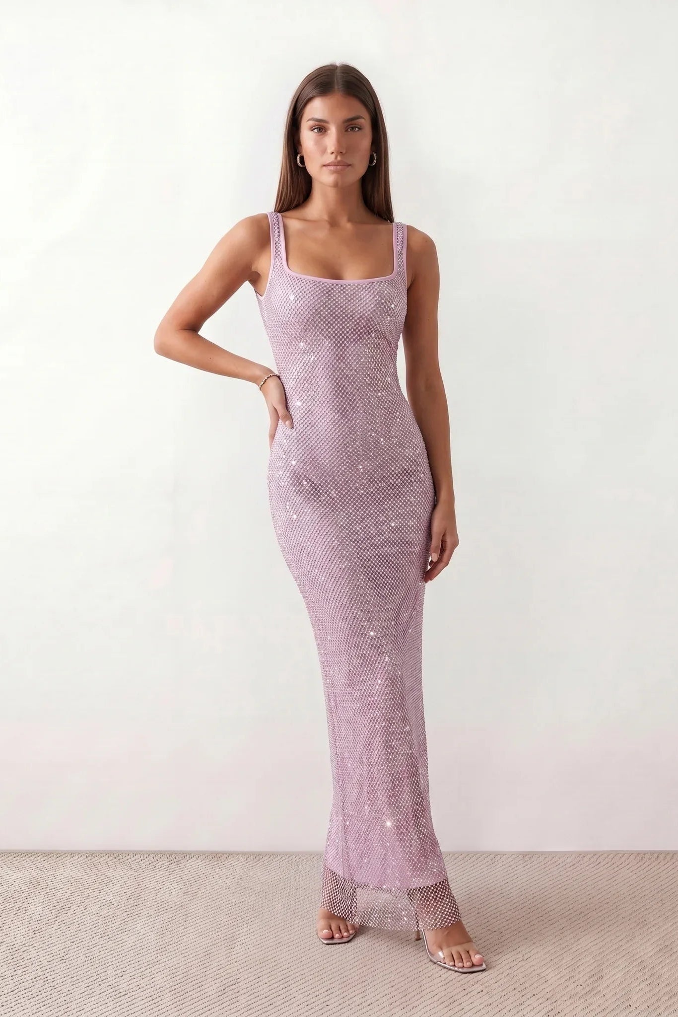 Woman wearing the Mihaela sequined low back maxi dress featuring allover sequin mesh, a square neckline, wide shoulder straps, a low open back, and a fitted floor-length sheath silhouette.