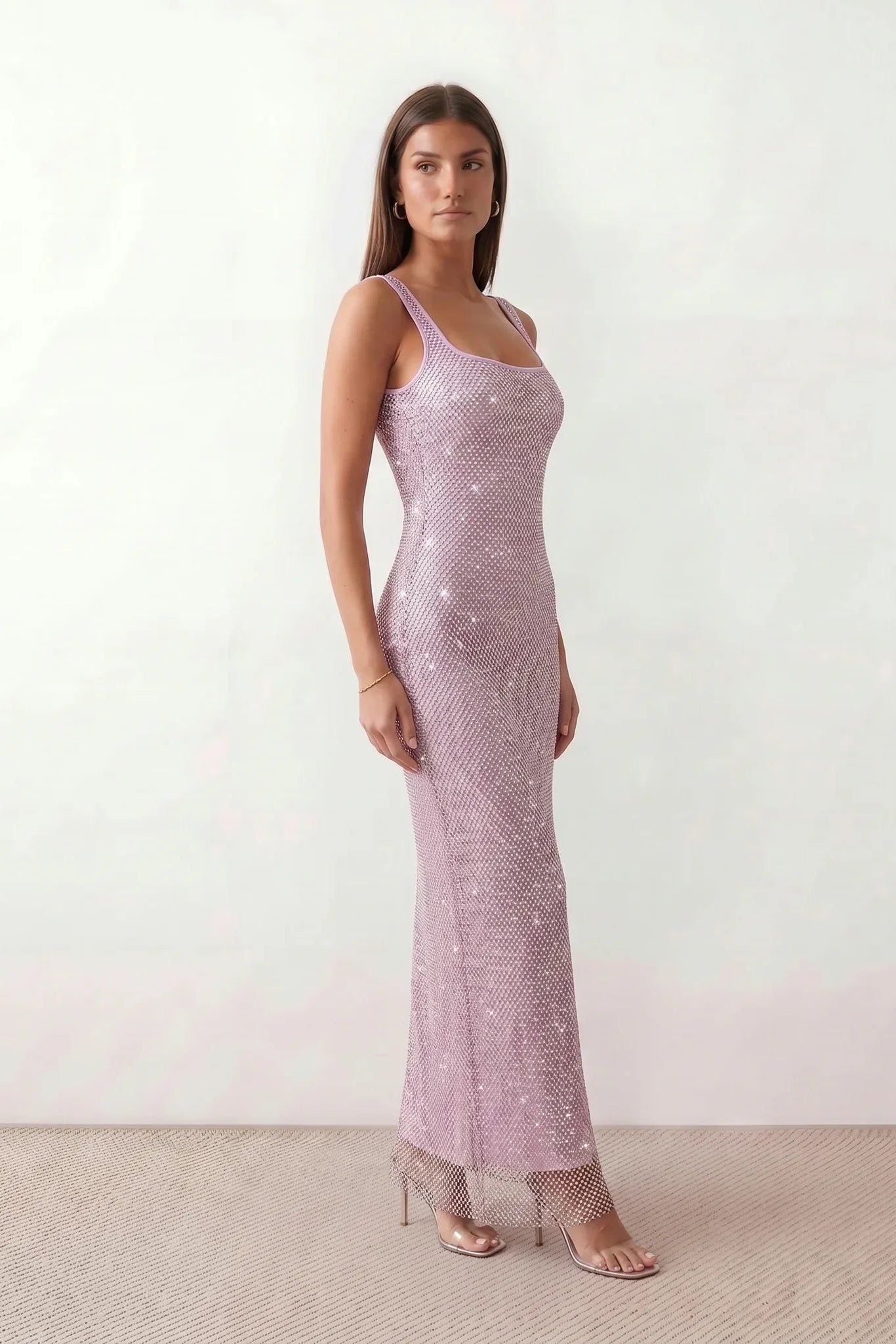 Woman wearing the Mihaela sequined low back maxi dress featuring allover sequin mesh, a square neckline, wide shoulder straps, a low open back, and a fitted floor-length sheath silhouette.
