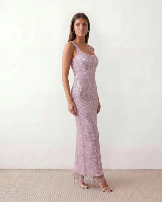 Woman wearing the Mihaela sequined low back maxi dress featuring allover sequin mesh, a square neckline, wide shoulder straps, a low open back, and a fitted floor-length sheath silhouette.