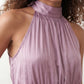 Bella Glossy Halter Mini Dress with a halter mock neckline, tie-back closure, smocked waist, open back, and tiered ruffle mini skirt in a glossy finish, available in Beige, Red, Purple, Yellow, Pink, and Light Blue.